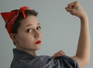 Colleen poses a la Rosie the Riveter with blue shirt, red bandana, and bright red lips